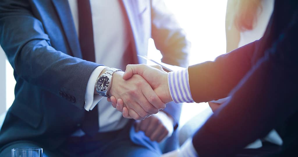 Apretón de manos entre dos ejecutivos durante una reunión de negocios